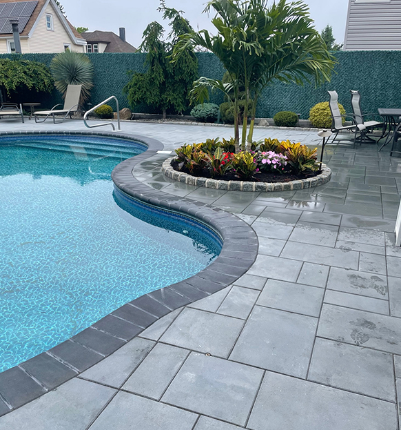 Ceramic pool in gray colors and a garden around it