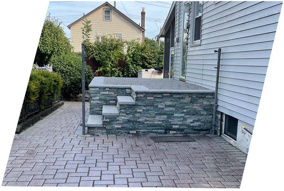backyard of a house with stairs and brick floor in gray tones