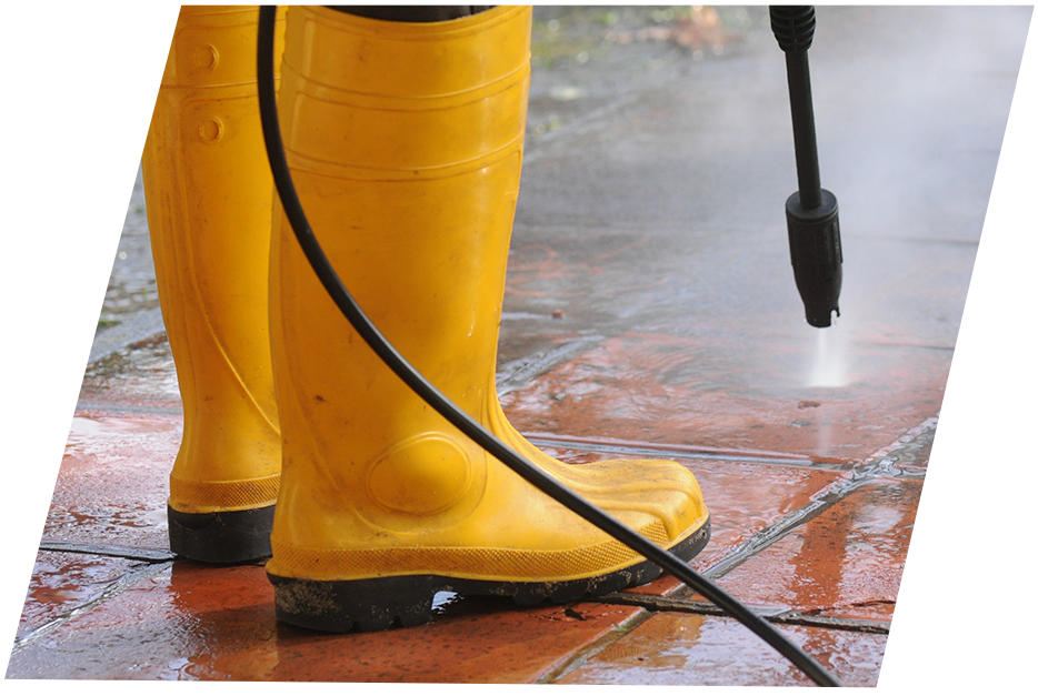 Person with yellow rubber boots using a pressure washer